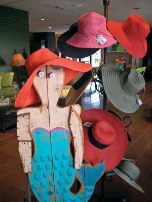 A unique wooden mermaid
adorned with accessories by San Diego Hat Co. greets customers as
they approach the checkout counter