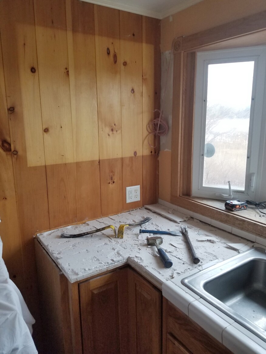 The first step was chipping the tile from the countertop. By taking care with the removal, the old cabinets could be repurposed for workshop storage.