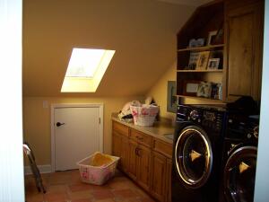 Rather than build out a costly and impractical 40-square-foot laundry room addition, Aurora Custom Remodeling found unused attic space to fill the same purpose. The original laundry space was turned into a mudroom.