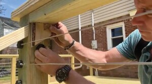 For stair rails, the bracket must be positioned on the post at the same angle as the railing. To accomplish this, the author cut a block at this angle, which he used to sight the angle of the bracket.