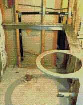 To hide the bracket's vertical leg, the author notched the framing 1/2 inch, then lag-bolted the bracket to the studs before hanging the drywall.