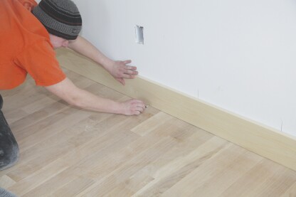 Scribing is a practice where a carpenter fits a finish element to an irregular or uneven surface. One common scribe is fitting baseboard to a hardwood floor.
