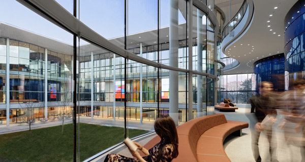 Each area between the elliptical classrooms and curved glazing features lively gatherings on banana-shaped furnishings.