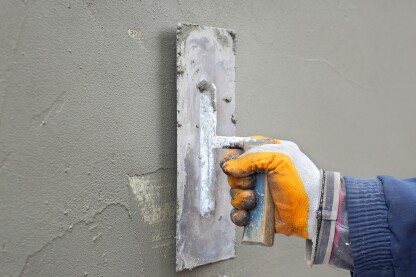 Worker spreading  mortar over styrofoam insulation with trowel
