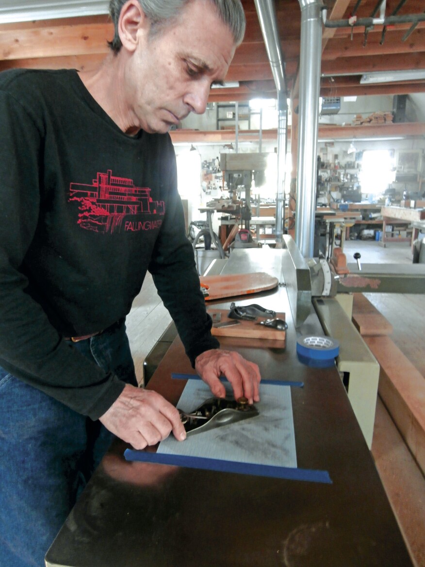 To tune a plane, the author starts by flattening and polishing the sole on a sheet of sandpaper taped to the bed of his jointer. Roll or break all the edges of the plane body.