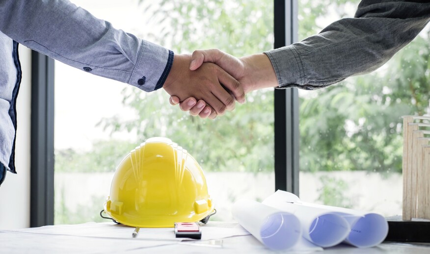 Construction professionals shaking hands over a deal.