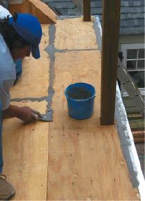 After installing the metal perimeter drip edge, the Duradek installers patch joints, nail heads, and voids in the plywood deck with a silica-based floor filler.