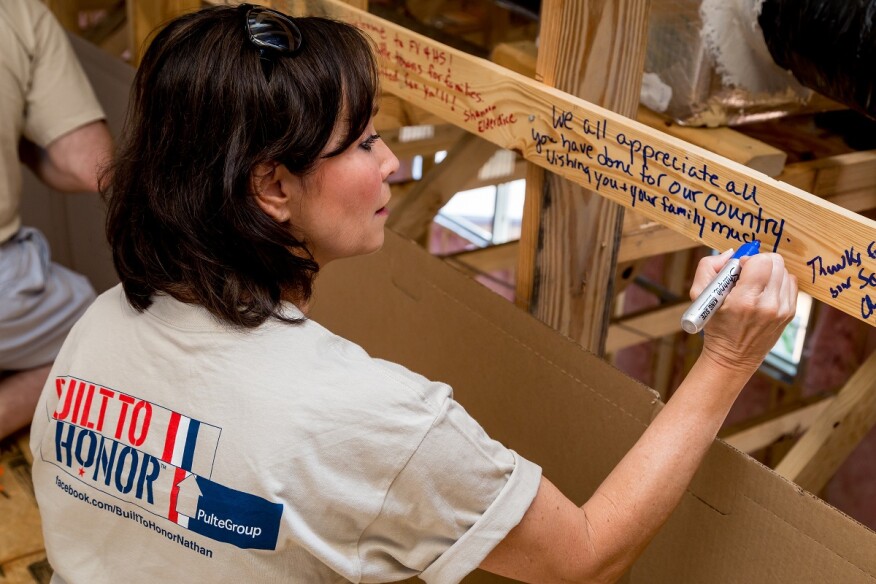Part of the program’s Notes of Love event, an employee of PulteGroup’s Raleigh division writes words of support on the stud of a future home.