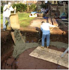 The 12-inch-deep by 2-foot-wide footing was dug by hand in the bottom of the excavation and reinforced with rebar.