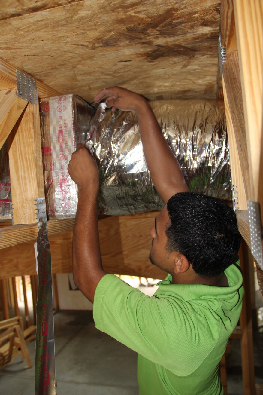 Finally, he tapes the flex duct outer liner to the box.