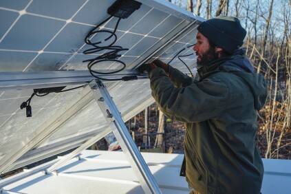 David Kelly encourages custom homebuilders to learn enough to install solar panels themselves as a way to gain a cost advantage. Here, Kelly makes basic modular wiring connections using snap connectors.