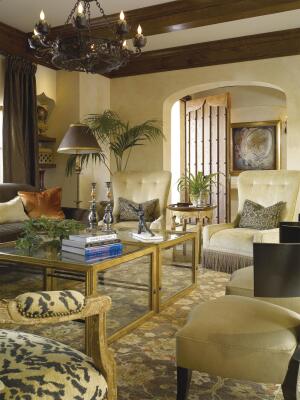 Beasley & Henley Interior Design worked with the home≠owners and the remodeler to transform this 3,000-square-foot 1950s house into a two-story, 6,900-square-foot villa. The new living room features cypress beams, custom wrought iron lighting, Venetian arches, and limestone floors.
