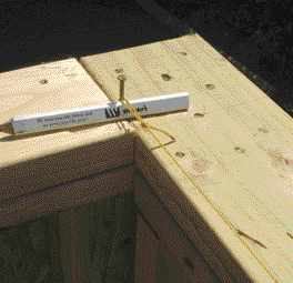 The author stretches a nylon line from end to end above the wall, then sights up from below to see whether the top plate is straight.