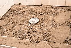 After half of the mortar bed is placed and troweled level, reinforcing wire is laid on the mortar bed and covered by the final layer of mortar.