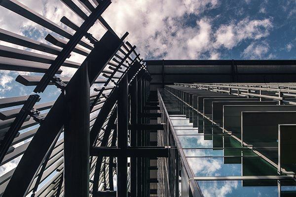A view skyward shows fixed sunshades on the building's south façade (right), with vertical, aluminum reeds to block solar gain on the west façade (left).