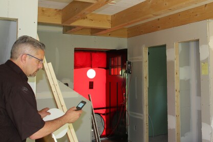 Figure 20. With the drywall installed, Jim Bradley, of Caleb Contracting, in Cambridge, Vt., performed the blower-door test in early June 2016 (Jim has to break out the blower door’s“D” ring—see video). The home averaged 76 cfm (65 cfm for depressurization and 87 cfm for depressurization), which translated to 0.45 air changes per hour at 50 Pascals—this is one really tight, high-performance country cottage.