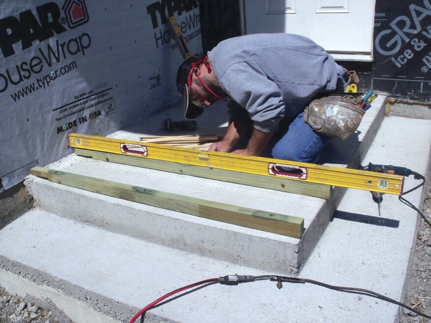 As I set each sleeper in place, I leveled down its length, adding treated shims to fill any voids below the fasteners.
