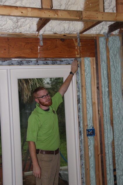 Hogan points out an air leak near the patio door.