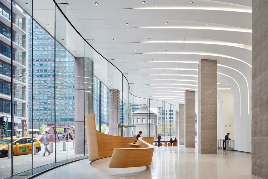 The lobby features a curved glass façade, a staggered layout of adjustables, and recessed cove lighting, following the curves of the architecture.