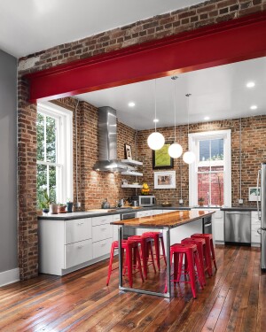 A renovated kitchen featuring a red painted structural beam is part of an open-concept living space in this Fayette Park residence in Lexington.