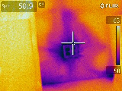 In this typical cold-season thermal image of a recessed electrical outlet in an exterior wall, the purple and pink show cold spots resulting from air leakage and compromised insulation.