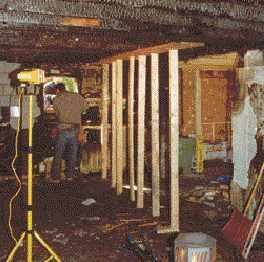 A fire can cause both obvious and hidden structural damage, creating dangerous working conditions. Here, temporary shoring supports weakened floor joists.