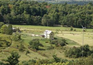 By definition, this net-zero home (top) produces at least as much energy as its occupants consume in operating heating, lighting, and other electrical appliances. It stands on a picturesque property (above) in northern Vermont and incorporated a wind turbine and a geothermal system--among other devices--to balance energy supply and demand.