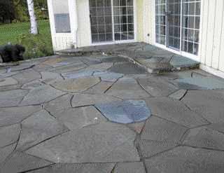 Polymer sand is swept into the joints, which locks the stones in place and minimizes weed growth.