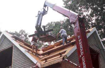 After staging is in place, shingles are boomed up and spread on the planks.