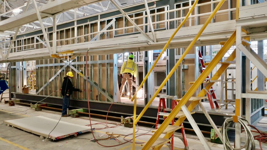 Two workers assemble a module in iBUILT’s factory.