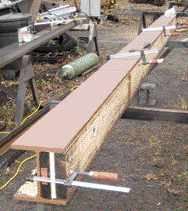 A sandwich of pressure-treated lumber and plywood bolted to one side of the I-beam provides a nailer for joist hangers.