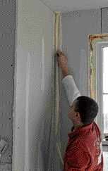 Then he grabs a precut length of tape and presses it into place with his fingers.