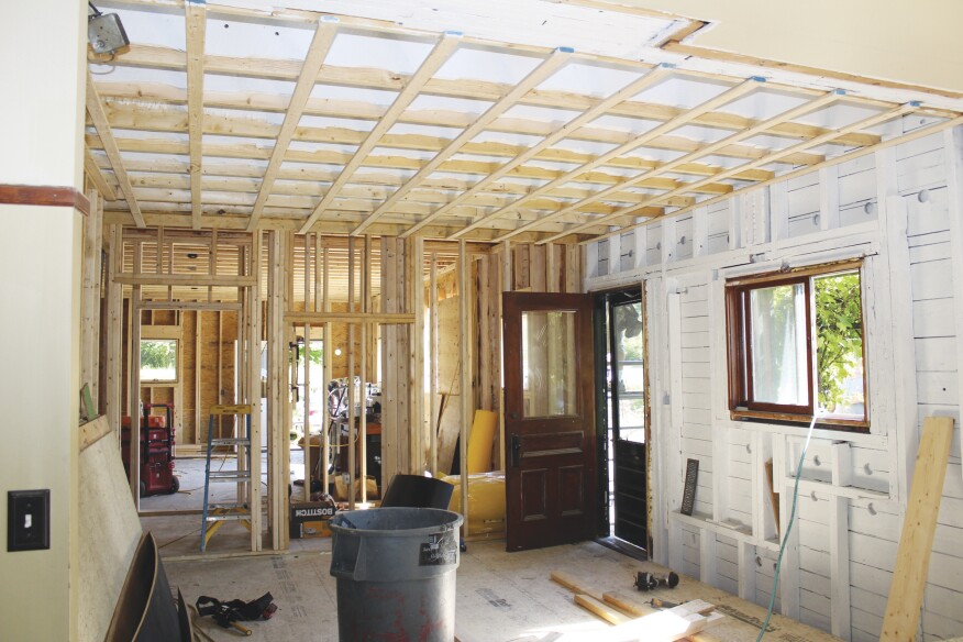 The existing ceiling and hardwood floors were removed in the connector’s kitchen area. Wall, ceiling, and roof framing was primed and left “open” for three months to air out.