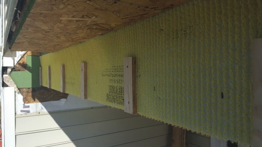 We installed Home Slicker, a matrix-type rainscreen, to the exterior side of the beam. Then we then installed 2-inch-wide strips of 3/4-inch marine plywood before attaching a 2x8 band.