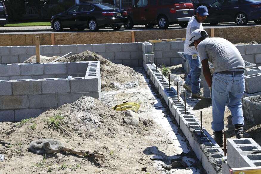 After letting the beams cure, the masons build short foundation walls. Lengths
of rebar are drilled and epoxied to tie the block to the grade beams, and the concrete block is then fully grouted.
