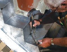 With the corner seam temporarily clamped in place — solders it to the top of stepped side flashing.