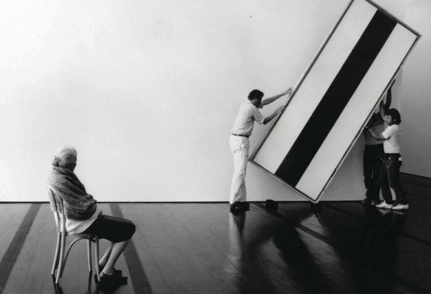 Dominique de Menil oversees workers as they hang a painting by Barnett Newman in the Menil Collection museum.