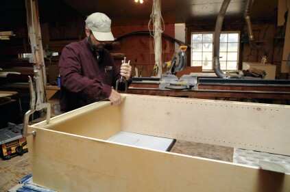 The author pocket screws a stretcher rail at the top of the cabinet for a place to attach the cabinet back as well as for a place to attach the cabinet to the wall.