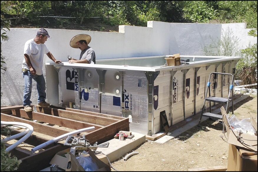 Figure 1. A work crew assembles a modular Endless Pool kit. The kit’s galvanized steel panels are bolted together, then insulated with rigid insulation.