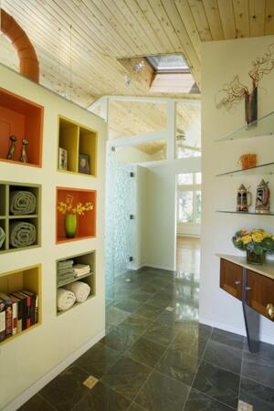 UNIQUE MATERIALS:  The clients wanted to show off their new master suite. Buckborough used glass panels in the transom above this doorway so viewers could see the expanse of white cedar ceiling. “It lets the space from the foyer feel like itís continuing,” Buckborough says. The single-pane tempered glass lends a more open feel to the space,brings light into the home, and adds visual interest.