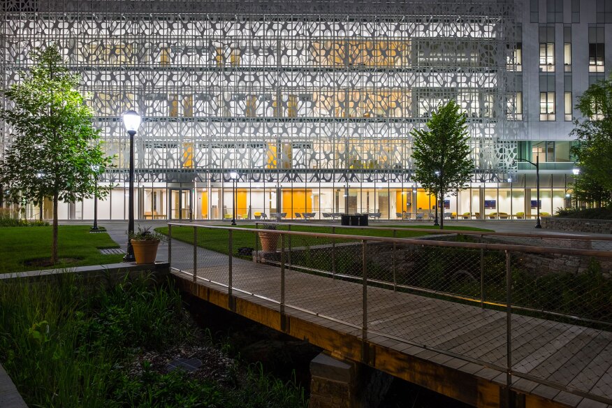 At night, the scrim acts as a veil, subtly revealing the building's interiors.