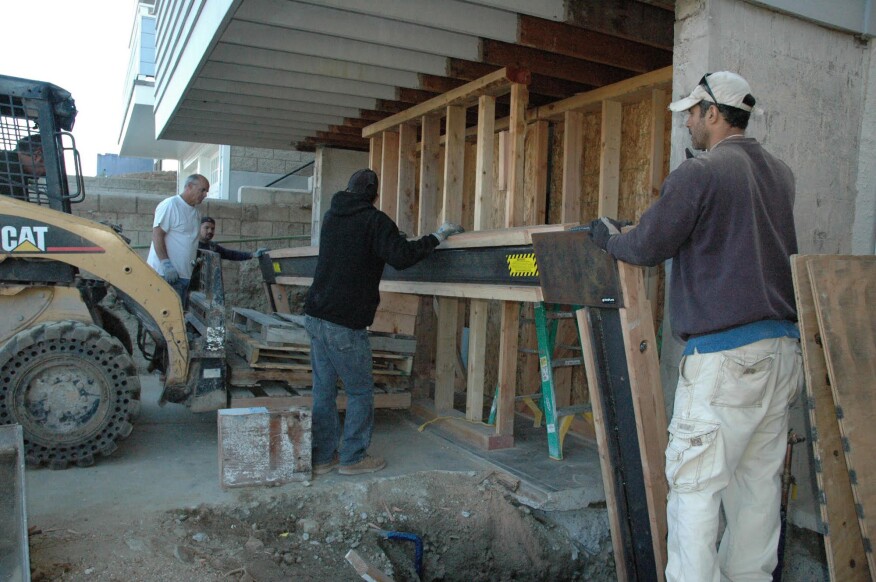 Placement. With the footings prepared and the shoring in place, the site is ready for the installation of the moment frame. Here, the installers have tilted the top of the frame back, away from the building, then moved it toward the point of installation and lowered the column bases into the foundation hole.