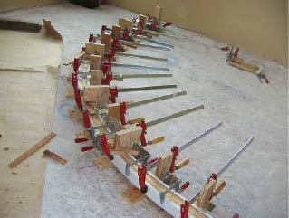 The balcony rail is bent in a similar manner, with wood wedges providing downward pressure.