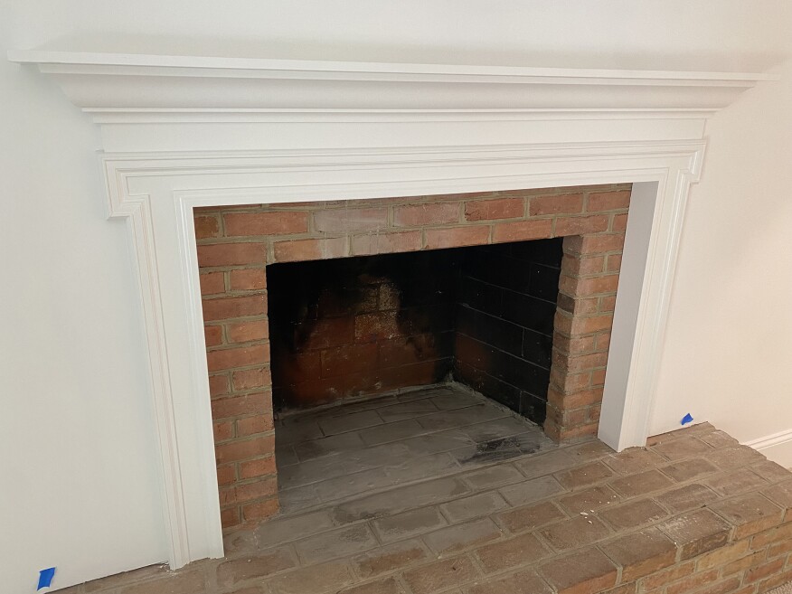 The modern-style mantel shown above does not meet code because the side trim projects roughly 4 inches out from the masonry facing within 8 inches of the firebox opening.