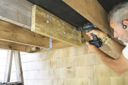 Blocking can be installed to help align the hardware with the deck and house framing. Here, the author fastened the block to the joist with SST TimberHex HDG screws.
