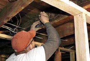 Then uses a small square to mark cut lines on the joists.