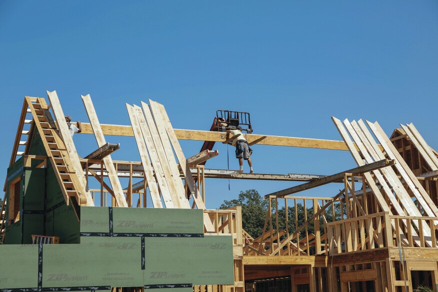 After releasing the straps holding the ridge on the telehandler forks, the crew was ready to install the ridge.