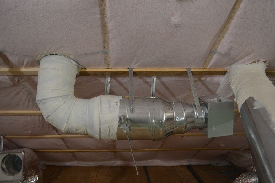 A makeup-air inlet with a weighted passive damper opens only if exhaust vent fans depressurize the house.