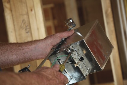 A slotted screwdriver removes the knockout for the switch leg.