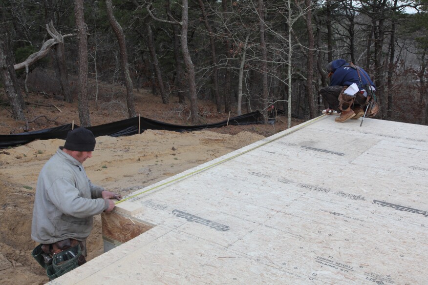 Crew members measure up from the original baseline to mark the position of the last short jog. This mark also sets the length of the perpendicular wall.